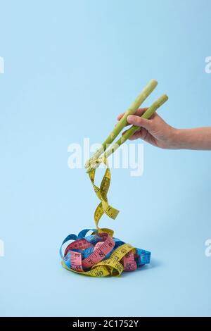 La mano della donna sta prendendo i nastri di misura dalle lance di asparago come bastoni. Foto Stock