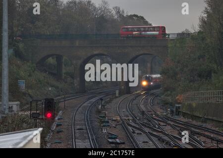 Treni Sud Ovest classe 444 treno 444026 che si avvicina da Surbiton sulla linea elettrica a 4 binari della terza linea sud-occidentale con un segnale rosso Foto Stock