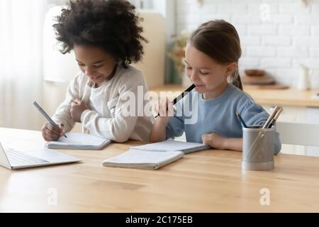 Due sorelle multietniche bambine che lavorano a casa Foto Stock