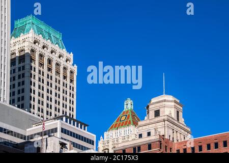 Vista dei tetti del centro di Tulsa Oklahoma, miscela di edifici Art Deco e moderni con una bandiera americana contro il cielo blu molto chiaro Foto Stock