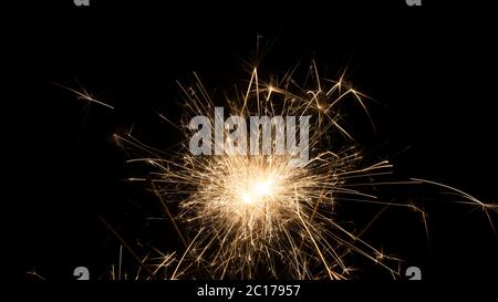 Stoppino con polvere da sparo illuminata da cui escono molte scintille su sfondo nero Foto Stock