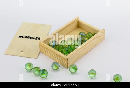 Scatola di legno di vetro verde marmi su sfondo bianco Foto Stock