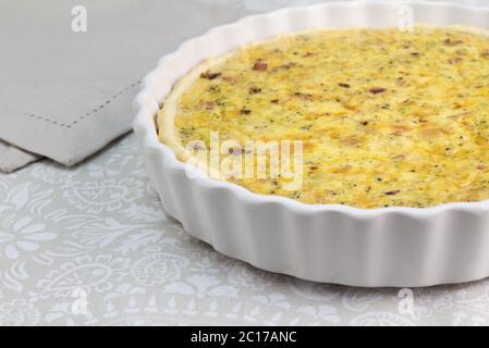 Quiche cremose con formaggio, pancetta e funghi - torta aperta in piatto bianco con fuoco selettivo - cibo b Foto Stock