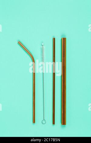 Provette in metallo riutilizzabile ambientale, in opposizione a provette monouso in plastica su sfondo turchese. Alternativa a stoviglie monouso, senza soluzione Foto Stock