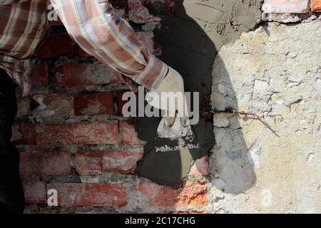 Muratore al lavoro con cazzuola e cemento Foto stock - Alamy