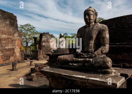Una statua di Buddha seduto all'interno del Vatadage che fa parte del Quadrangle presso l'antico sito di Polonnaruwa in Sri Lanka. Foto Stock