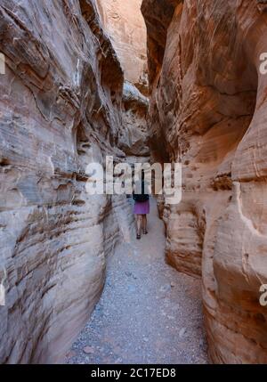 Donna cammina attraverso slot Canyon Foto Stock