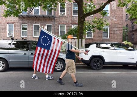 New York City, Stati Uniti. 14 Giugno 2020. Per celebrare la Giornata Nazionale della Bandiera, un uomo porta una bandiera "Betsy Ross" lungo Skillman Avenue, nel quartiere delle Regine di New York City, NY, 14 giugno 2020. La Giornata nazionale della bandiera commemora l'adozione della bandiera degli Stati Uniti il 14 giugno 1777 con risoluzione del secondo Congresso continentale. (Anthony Behar/Sipa USA) Credit: Sipa USA/Alamy Live News Foto Stock