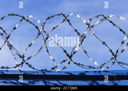 Filo spinato. Filo spinato sulla recinzione con cielo blu per sentirsi preoccupanti. Foto Stock