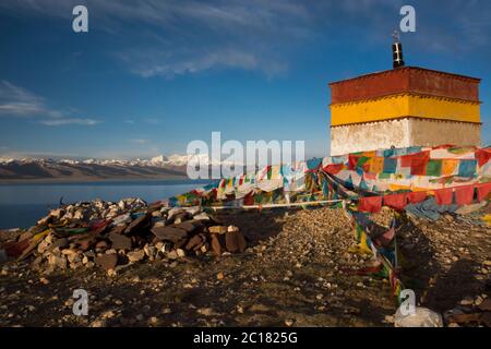 Uno stupa con offerte massicce di bandiere, pietre mani e teschi di yak, penisola di Tashi Dor, lago Nam, Tibet Foto Stock