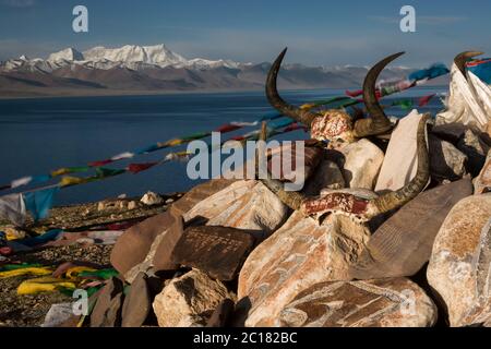 Pietre mani, teschi di yak e bandiere di preghiera in un'offerta massiccia, la penisola di Tashi Dor, il lago Nam, il Tibet Foto Stock