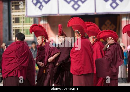 I giovani monaci si preparano a partecipare ai rituali durante il festival del monastero di Tsurphu, in Tibet Foto Stock