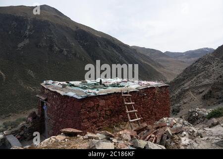 Piccoli eremi punteggiano il sentiero di pellegrinaggio del monastero di Tsukhu, il Tibet Foto Stock