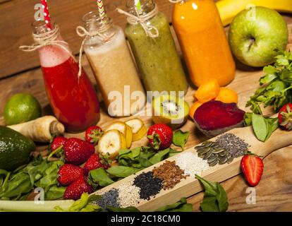 Assortimento di frullati di frutta e verdura in bottiglie di vetro con pescanti Foto Stock