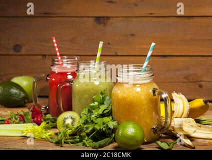 Assortimento di frullati di frutta e verdura in vasetti di vetro con cannucce Foto Stock