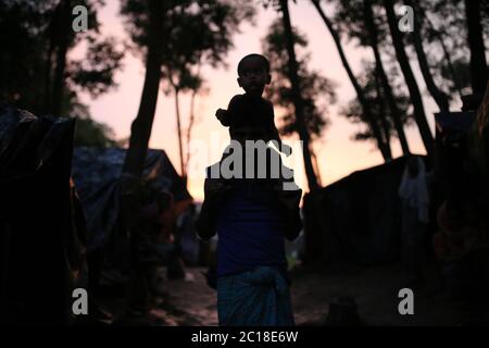 Un uomo Rohingya cammina portando il suo bambino al campo profughi di Kutupalong, Bangladesh, Martedì, 03 ottobre 2017. Foto Stock