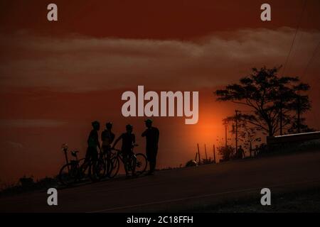 I ciclisti si fermavano a riposare al tramonto. Foto Stock