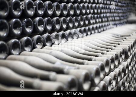 Bottiglie di champagne in cantina impilate e polverose Foto Stock