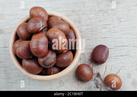 Castagne arrostite su pavimento in legno. Foto Stock