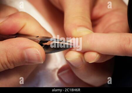 manicurista ai corsi di formazione mostra agli studenti come maneggiare le unghie con l'aiuto di pinze cuticle prima di applicare la gommalacca. Foto Stock