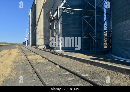 Binari ferroviari che corrono lungo elevatori di grano Foto Stock