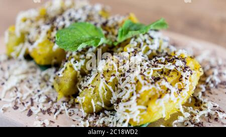 Pisang Goreng Keju è una specialità malese e indonesiana, con frittelle di Banana ricoperte di formaggio, cioccolatini grattugiati e latte condensato. Foto Stock