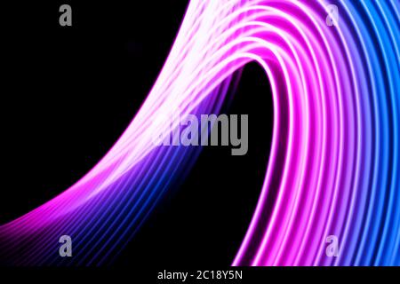 Colorato di rosa e blu a spirale al neon linee.sfondo astratto di neon blu luce incandescente forme. Strisce luminose per poster, sito Web, brochure, stampa. Foto Stock