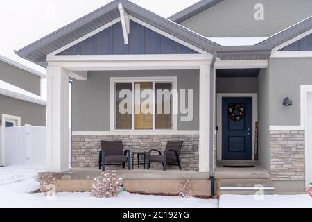 Home facciata con tetto apribile portico anteriore e porta con corona in inverno Foto Stock