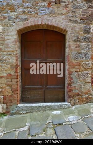 Vecchia porta di legno in un muro di mattoni Foto Stock