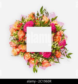 Layout creativo fatto di fiori e foglie con carta di nota. Disposizione piatta Foto Stock