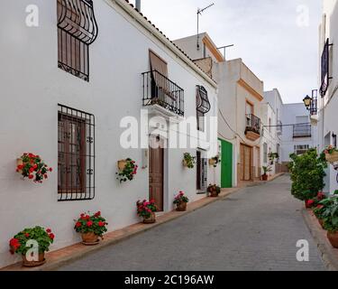 Strade di una città bianca chiamata Lucanena de las Torres in Spagna. Alcuni fiori e balconi. Foto Stock