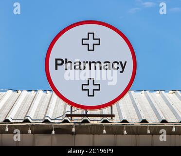 Un cartellone circolare con testo Farmacia, è installato su un tetto. Segno di Drugstore. Foto Stock