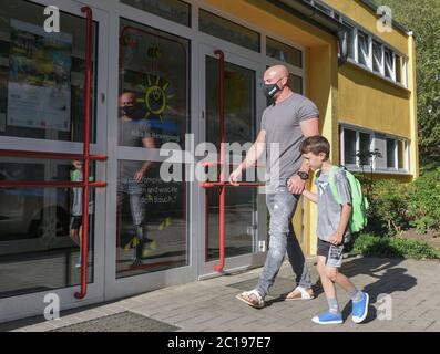 15 giugno 2020, Brandeburgo, Francoforte (Oder): Fabian Jänicke porta il suo figlio di sei anni Tijn all'asilo. Da lunedì, i Brandenburgers avranno ancora più libertà nella vita quotidiana. Amici, conoscenti e parenti possono incontrarsi di nuovo senza le restrizioni di contatto di due famiglie o fino a dieci persone. Dopo circa tre mesi, i centri di assistenza diurna riapriranno per tutti i bambini su 15.06.2020. La regola della distanza verrà sospesa. Da marzo sono in vigore solo le cure di emergenza e, più recentemente, le operazioni limitate. A Berlino, i centri di assistenza diurna tornano anche a n. Foto Stock