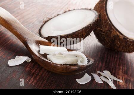 Olio di noce di cocco in cucchiaio sul tavolo di legno. Foto Stock