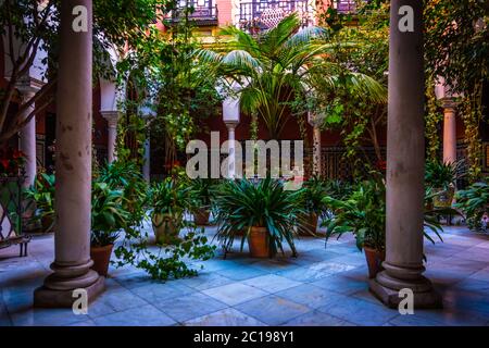 Tipico patio andaluso con fontana e numerose piante gerani e garofani sulle pareti. Cordoba, Spagna Foto Stock