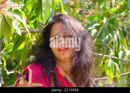 Una bella ragazza in giardino con capelli sparsi Foto Stock