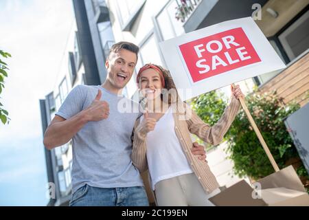 Sorridente felice coppia pronta per il trasferimento in un nuovo appartamento e sentirsi eccitato Foto Stock