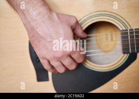 Mano musicista su chitarra acustica. Primo piano Foto Stock