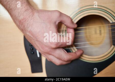 Mano musicista su chitarra acustica. Primo piano Foto Stock