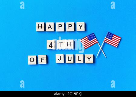 L'iscrizione del 4 luglio in lettere di legno su sfondo blu. Disegno dell'iscrizione per il giorno dell'indipendenza americana. Modello sfondo per greeti Foto Stock