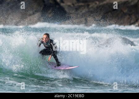 Un giovane surfista femmina a cavallo di un onda al Fistral a Newquay in Cornovaglia. Foto Stock