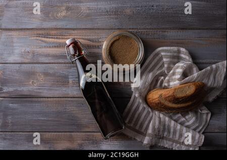 Vista dall'alto, kvass russo tradizionale fatto in casa in bottiglia di vetro con lievito e pane. Ottima bevanda rinfrescante per l'estate Foto Stock