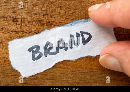 Concetto di marca e tema scritto su carta vecchia su uno sfondo grunge Foto Stock