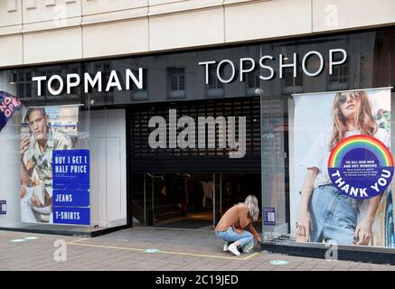 Loughborough, Leicestershire, Regno Unito. 15 giugno 2020. Un lavoratore solleva le persiane su un negozio di abbigliamento Topman Topshop, mentre i negozi non essenziali riaprono in Inghilterra dopo che le restrizioni pandemiche di coronavirus sono state attenuate. Credit Darren Staples/Alamy Live News. Foto Stock