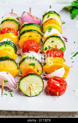 Spiedini grigliati di verdure su una piastra rettangolare grigia. Concetto di cibo vegano. Foto Stock