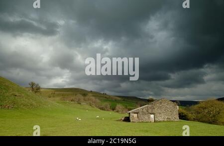 Vista panoramica delle Cumbrian Hills con il vecchio fienile e le nuvole tempesta, Cumbria, Inghilterra, Regno Unito Foto Stock