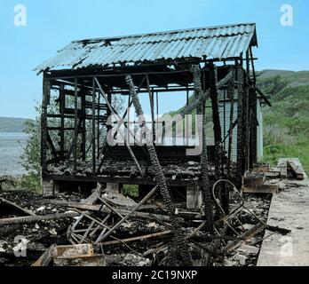 Casa di villaggio bruciato. Casa bruciata, resti di bruciato, casa distrutta, spazzatura dopo un incendio Foto Stock
