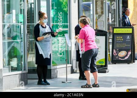 Exeter, Devon, Regno Unito. 15 giugno 2020. I negozi che vendono articoli non essenziali hanno permesso di riaprire oggi, poiché il blocco del coronavirus è ulteriormente facilitato. Gli Specsaver Opticians si trovano nella High Street di Exeter in Devon, con personale in DPI a porte chiuse per salutare i clienti. Immagine: Graham Hunt/Alamy Live News Foto Stock