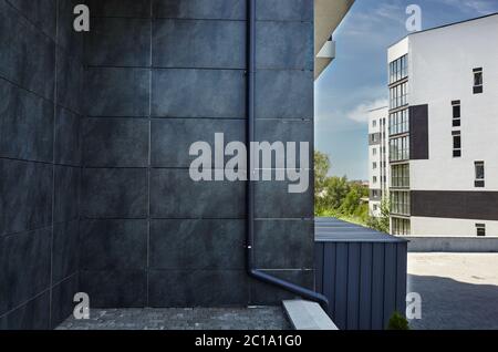 Facciata di un moderno edificio di appartamenti europei con scarico. Moderni edifici di appartamenti in una giornata soleggiata con un cielo blu Foto Stock