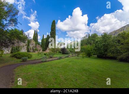 Giardino di Ninfa (Latina, Italia) - un monumento naturale privato con rovine medievali in pietra, parco fiorito e un impressionante torrente con poca caduta. Foto Stock